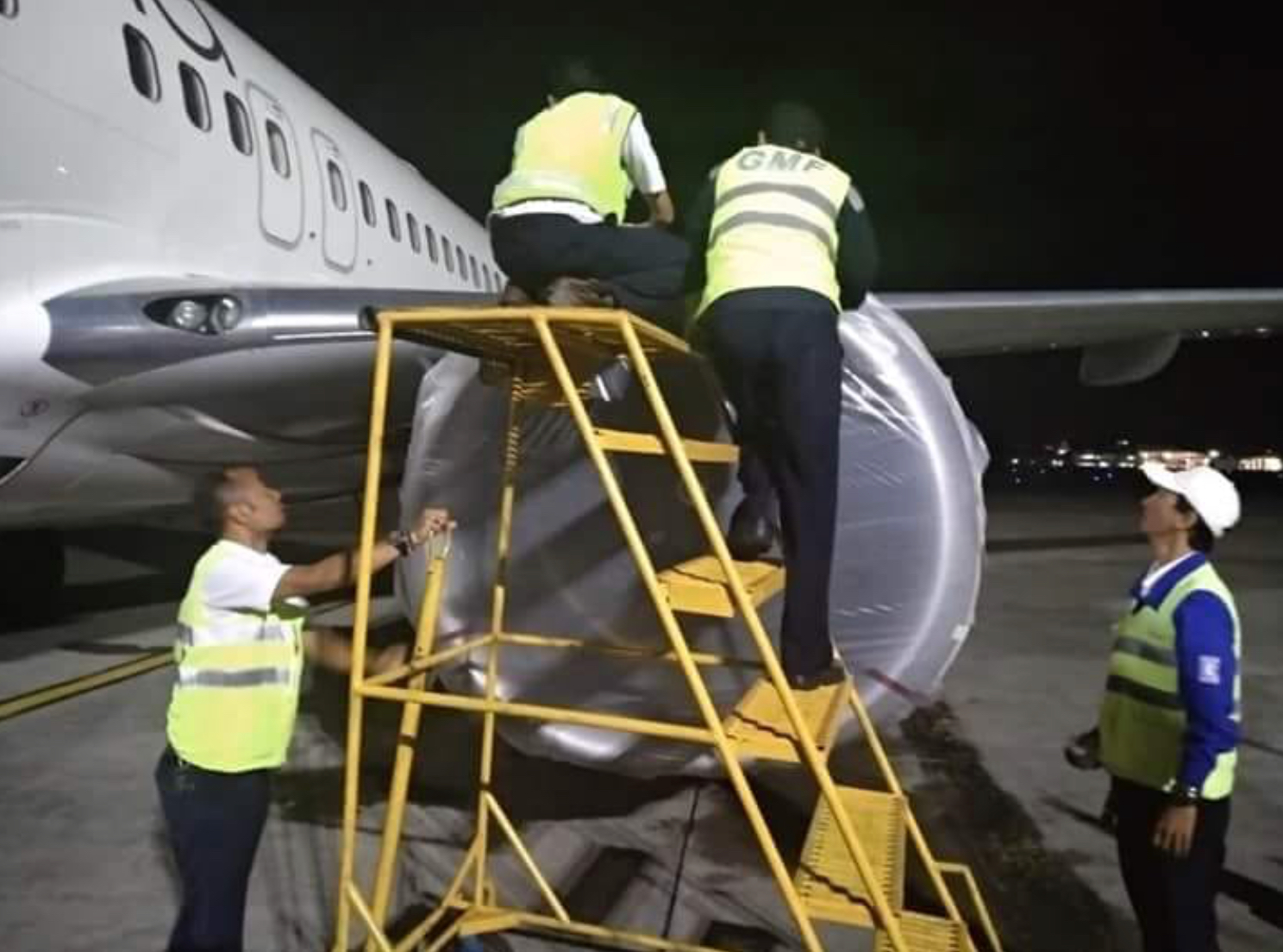 Ground staff secure the plane, anticipating ash fall at Bali’s airport. Photo: BNPB