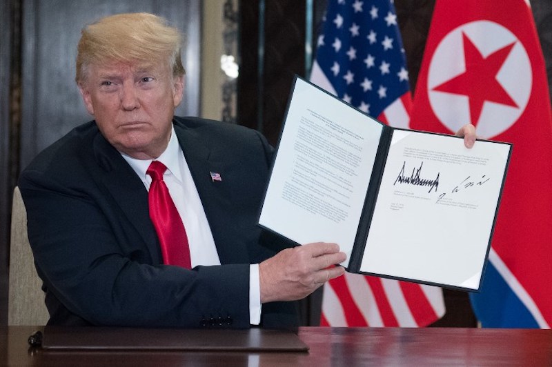 US President Donald Trump holds up a document signed by him and North Korea’s leader Kim Jong Un following a signing ceremony during their historic US-North Korea summit, at the Capella Hotel on Sentosa island in Singapore on June 12, 2018.

Photo: Saul Loeb / AFP 