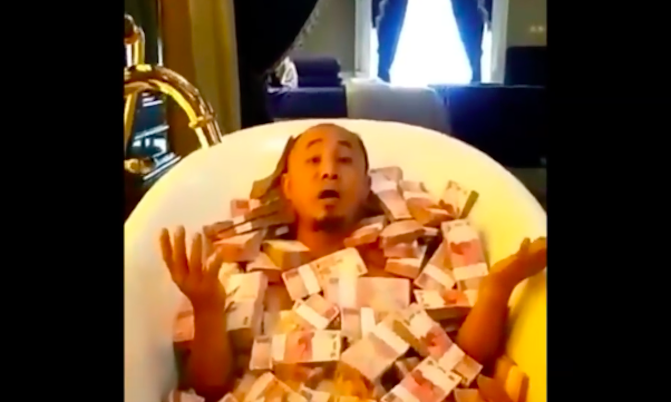 Indonesian man bathing in stacks of IDR100K notes — his Ramadan blessing — in a viral video.