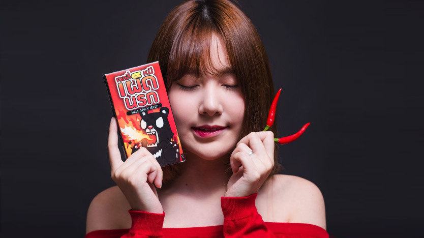 A woman poses with Hell Spicy Jelly and a few regular Thai chilies – not Carolina Reapers.  