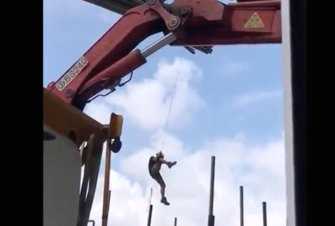 A screengrab via YouTube of the worker dangling from a crane at a construction site in Tseung Kwan O