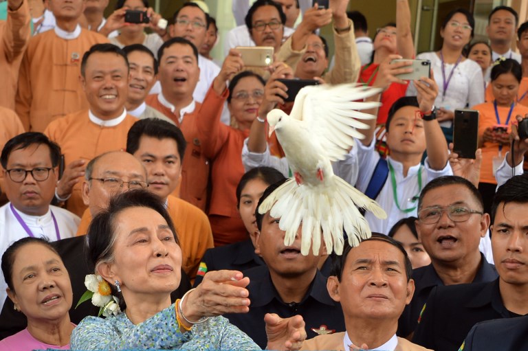 Myanmar State Counsellor Aung San Suu Kyi releases a dove during a celebration marking her 73rd birthday at the parliament house in Naypyidaw on June 19, 2018 while President Win Myint (3rd-R) looks on. / AFP PHOTO / Thet AUNG