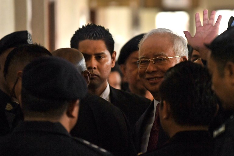 Former Malaysian prime minister Najib Razak (centre R) waves as he is transferred to a high court after an appearance at the Duta court complex in Kuala Lumpur on July 4, 2018.
Najib, 64, was detained on July 3 as the government of Prime Minister Mahathir Mohamad intensified a probe on corruption during his rule, including the alleged siphoning off of billions of dollars from state fund 1MDB. / AFP PHOTO / MOHD RASFAN