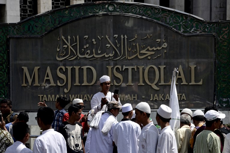 This picture taken on July 6, 2018 shows a group of Indonesian Muslim men gathering to take photos at the Istiqlal mosque in Jakarta.  AFP PHOTO / GOH CHAI HIN 