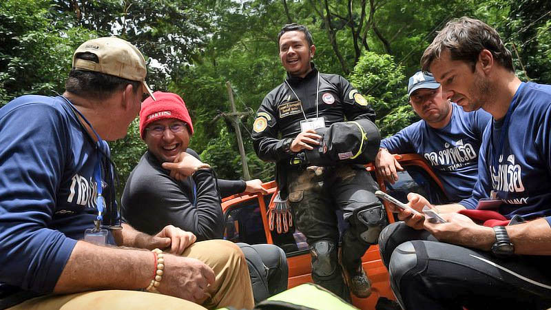 Belgian diver Ben Reymenants (right) and his team members chat before being escorted by a Thai rescue worker to Luang Cave on July 1. Photo: Lillian Suwanrumpha / AFP