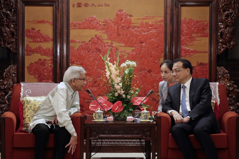 Malaysia's new government advisor Daim Zainuddin (L) talks to Chinese Premier Li Keqiang during their meeting at the Zhongnanhai Leadership Compound in Beijing on July 18, 2018. / AFP PHOTO / POOL / Andy Wong