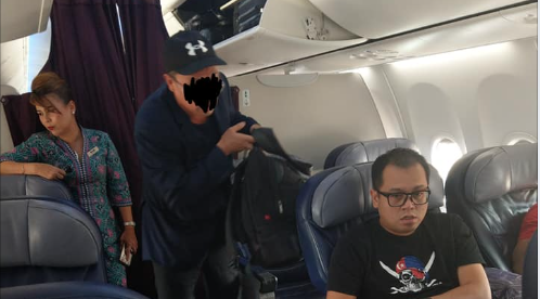 Suspect being escorted off the plane via Faiz Mokhtar Facebook