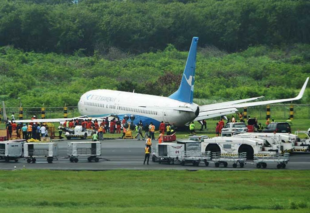 A XiamenAir Boeing 737-800 series passenger aircraft, operating as flight MF8667 from Xiamen to Manila, is seen after skidding off the runway while attempting to land in bad weather at the Manila international airport. Wet passengers (left) with blankets line up at the immigration counter after getting out of the disabled Xiamen aircraft. AFP / Jerry S. Tan