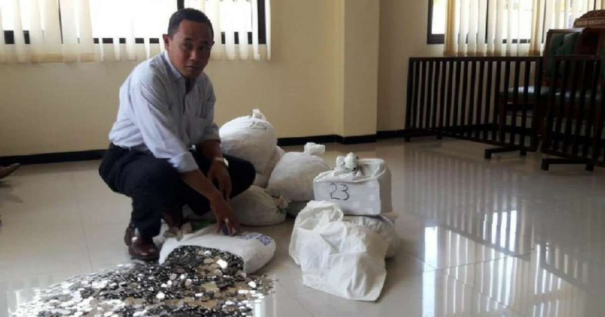 Dwi Susilarto’s lawyer Sutarto showing the court his client’s payment in small coins. Photo: Sutarto