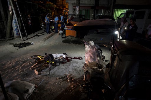 The body of an alleged drug dealer lies on the ground after he was killed by an unidentified assailant in Manila on March 23, 2018. (Photo: Noel Celis of AFP) 