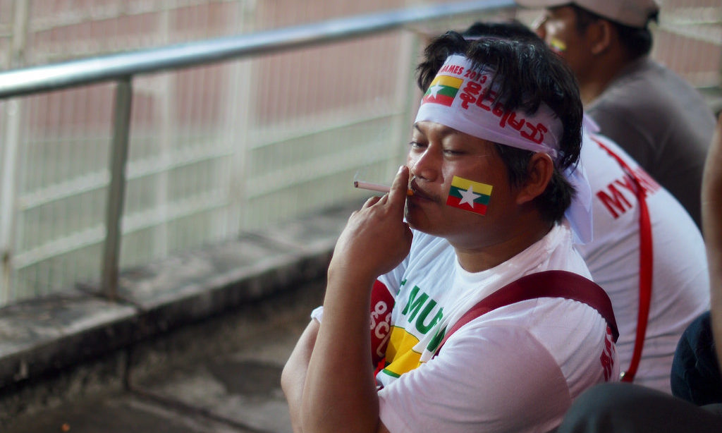 A man smokes in a Yangon football stadium, where smoking is banned. Photo: Flickr / William