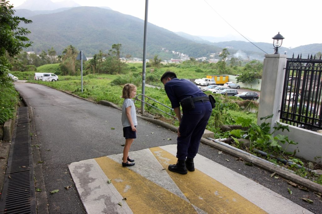 Inspector Tommy Tse talks with a young bystander in Sai Kung. The girl mentioned she had a hamster. Tse also has a pet: a dog named Dodge that he rescued, then adopted, a few years ago. Picture: Coconuts HK