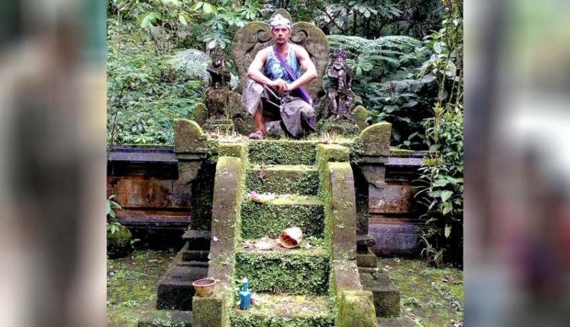 A photo of a foreign tourist inappropriately sitting on a holy Balinese temple has gone viral. Photo via Nusa Bali