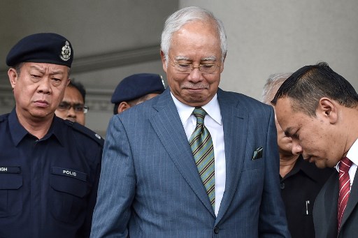 Malaysia's former prime minister Najib Razak (C) reacts as he leaves Duta court complex in Kuala Lumpur on August 8, 2018.Malaysia's former prime minister Najib Razak was hit with new charges on August 8 linked to the multi-billion-dollar 1MDB financial scandal that contributed to his shock election defeat in May. / AFP PHOTO / Mohd Rasfan 