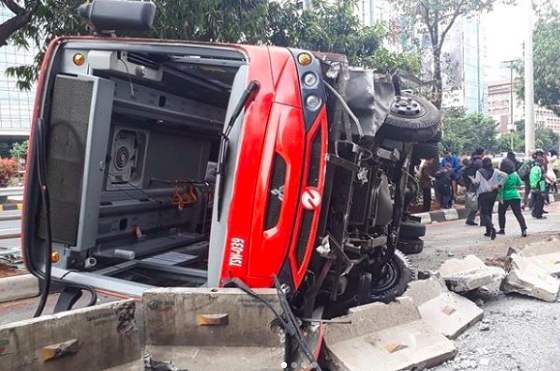 A Minitrans bus toppled onto its side in South Jakarta after crashing with road barrier on Sept 20, 2018. Photo: Instagram/@jktinfo