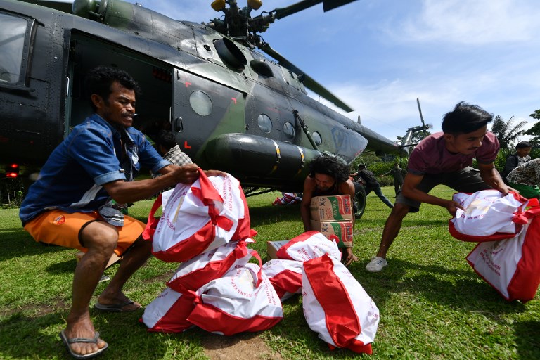 Indonesian villagers receive aid at the Proo village, Lindu district in Sigi on October 7, 2018. 
Aid poured into disaster-ravaged Palu on Sunday after days of delays as efforts ramped up to reach 200,000 people in desperate need following a deadly quake-tsunami in the Indonesian city. / AFP PHOTO / ADEK BERRY