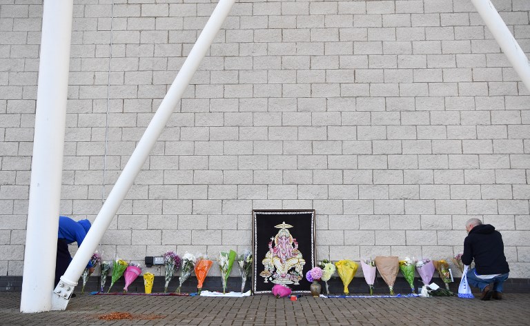 A supporter adds flowers and a Leicester City scarf to floral tributes lined up outside Leicester City Football Club’s King Power Stadium in Leicester, eastern England, on October 28, 2018 after a helicopter belonging to the club’s Thai chairman Vichai Srivaddhanaprabha crashed outside the stadium the night before. – Leicester City’s charismatic Thai chairman was the subject of growing concerns on October 28 after a helicopter belonging to the billionaire crashed and burst into flames in the stadium carpark shortly after taking off from the club’s pitch following the match against West Ham United on October 27. There was no confirmation whether London-based Vichai Srivaddhanaprabha, who frequently flies to and from Leicester’s home games by helicopter, was on board the aircraft which appeared to develop mechanical problems. (Photo by Ben STANSALL / AFP)