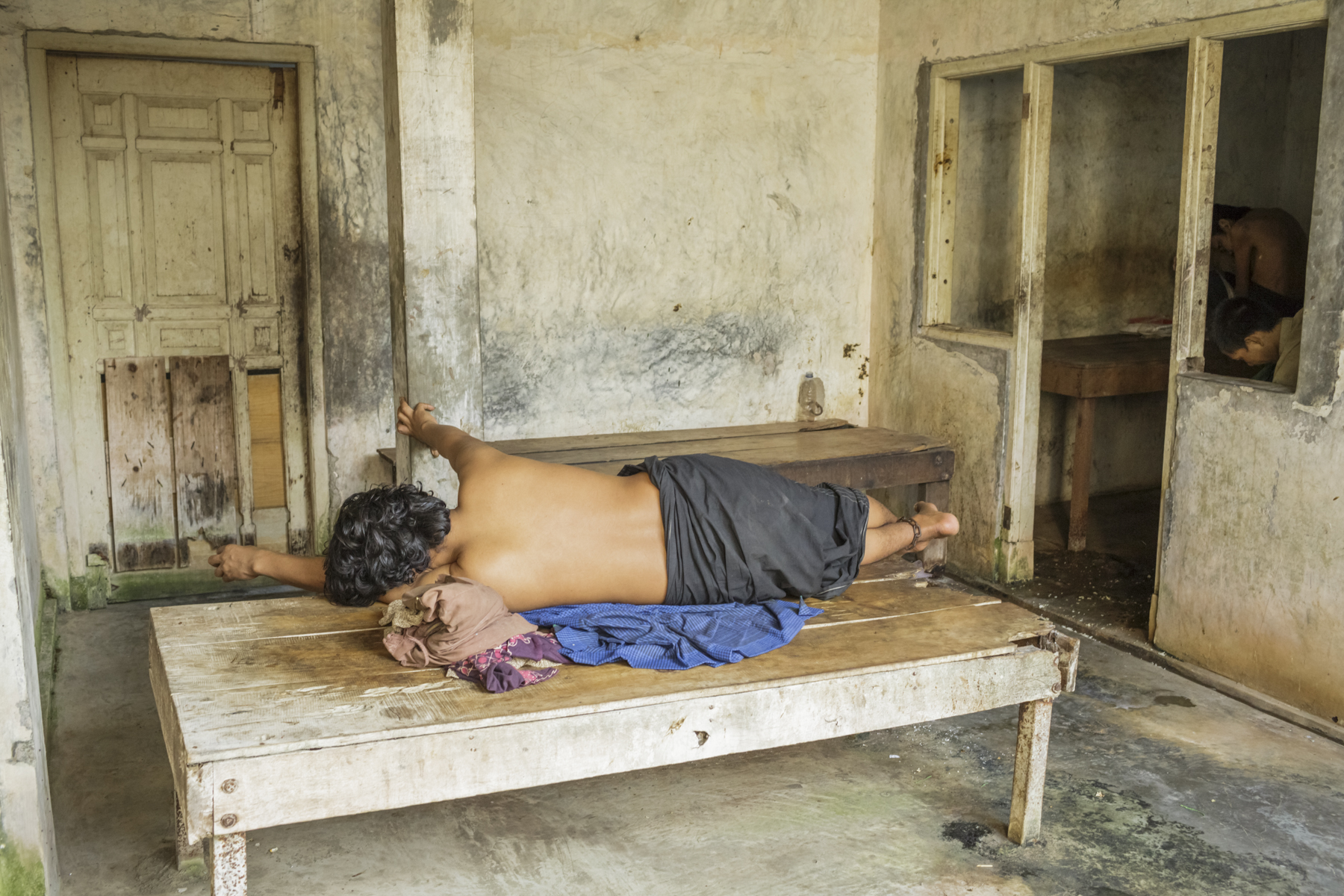 A man with a real or perceived psychosocial disability lying with his ankle chained to a platform bed in the Syamsul Ma’arif faith healing center in Brebes, Central Java. Photo: Andrea Star Reese for Human Rights Watch