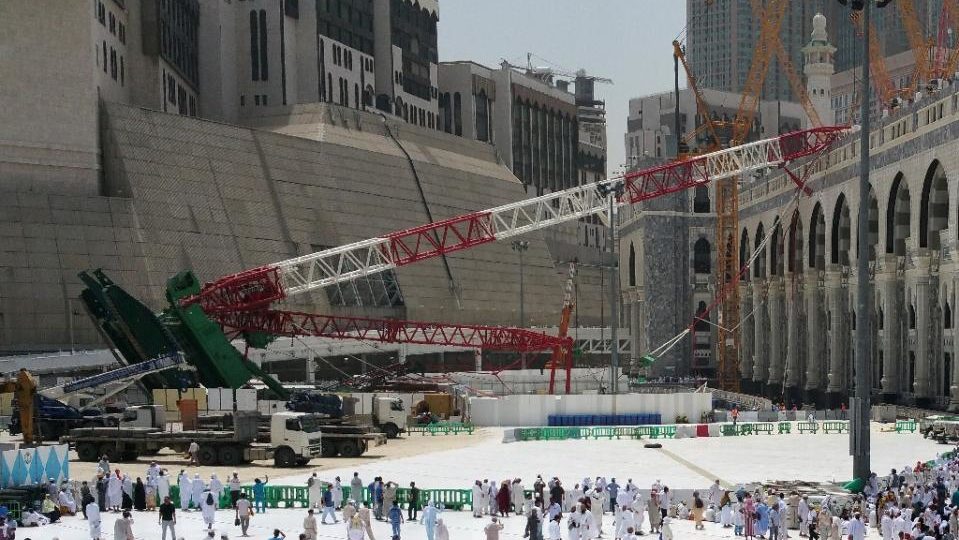 Muslim pilgrims walk past the crane that had collapsed the day before at the Grand Mosque in Saudi Arabia’s holy city of Mecca on September 12, 2015. Photo: AFP