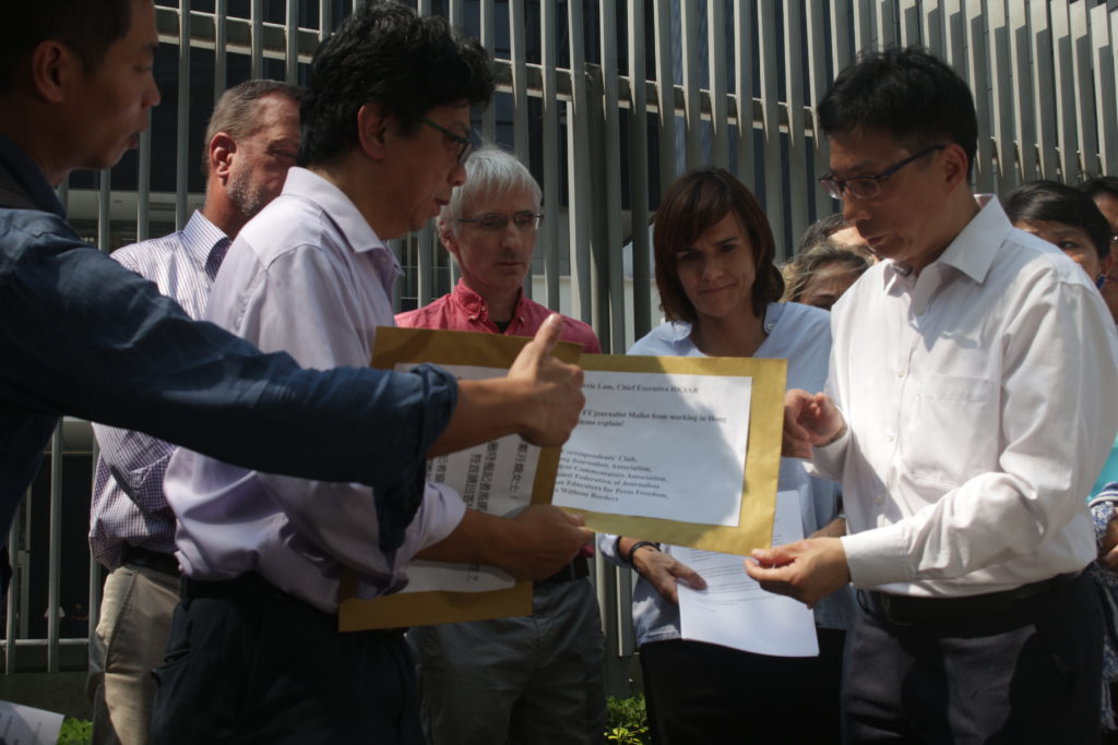 HKJA chairman Chris Yeung hands a petition bearing 15,000 signatures from people demanding the government explain why Victor Mallet's visa was not renewed. Photo by Vicky Wong.