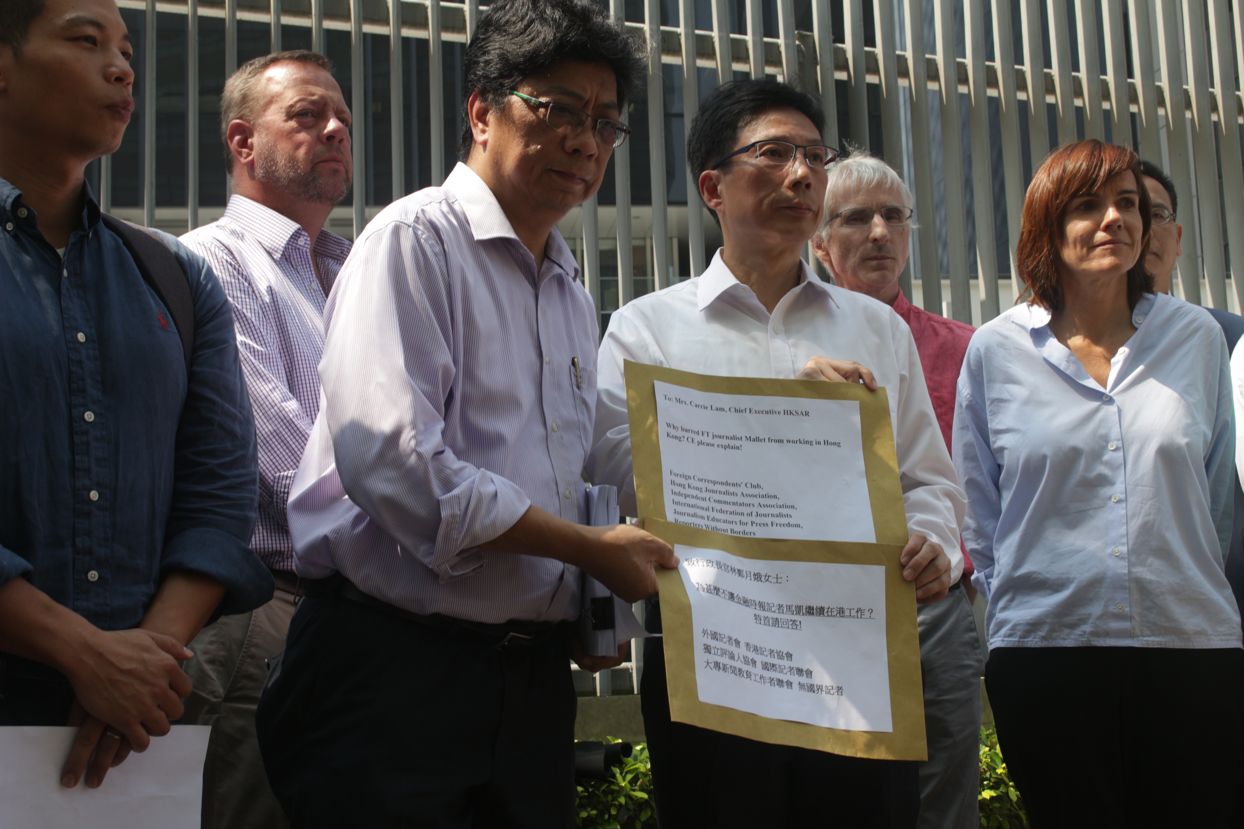 HKJA chairman Chris Yeung hands a petition bearing 15,000 signatures from people demanding the government explain why Victor Mallet’s visa was not renewed. Photo by Vicky Wong.