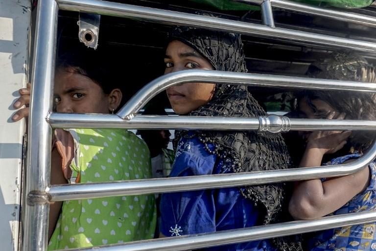 Rohingya Muslim women ride a police vehicle in Kyauktan township south of Yangon on November 16, 2018 after their boat washed ashore. (Photo by Hla-Hla HTAY / AFP)