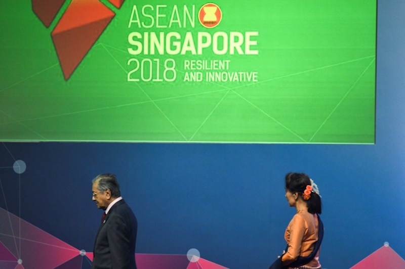 Malaysia’s Prime Minister Mahathir Mohamad (L) and Myanmar State Counsellor Aung San Suu Kyi leave the stage after posing for a group photo at the opening ceremony during the 33rd ASEAN summit in Singapore. Photo: Jewel Samad / AFP
