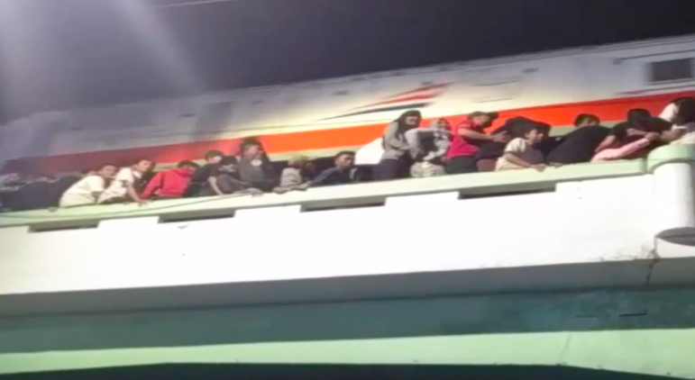 A crowd of spectators for a historical theater performance dangerously watching from a railway overpass in Surabaya. Three people were killed after falling off the overpass on Nov. 9, 2018. Photo: Youtube screengrab