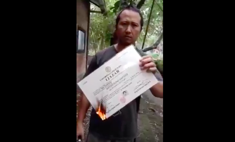 An alumnus of Indonesia’s Universitas Gadjah Mada burning his own diploma over the university’s lack of action in an alleged rape case of a student. Photo: Video screengrab from Youtube