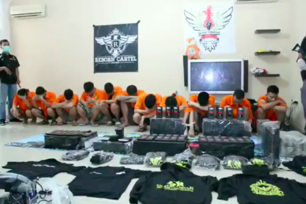 11 suspects, arrested for involvement in an illegal narcotics-laced vape liquid business, sitting behind evidence presented by the police. Photo: Instagram / @jktinfo