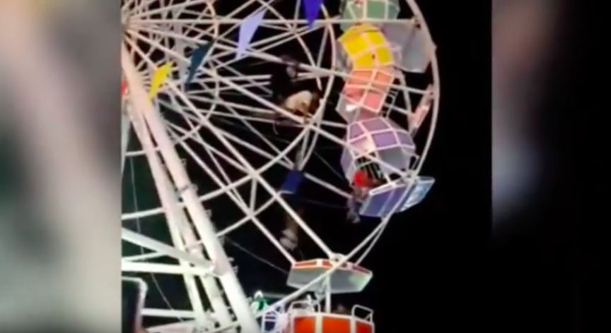 People hanging on for dear life on a ferris wheel in Indonesia after some of its pods flipped due to a suspected technical malfunction. Photo: Youtube screengrab