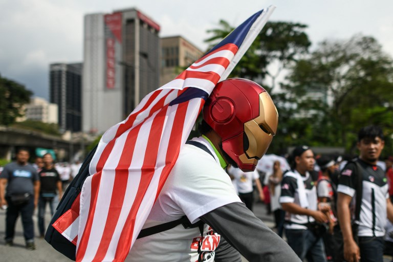 A protester wearing a mask of Marvel Comics character Iron Man carries a Malaysia national flag during a rally organised by Muslim politicians against the signing of the UN anti-discrimination convention (ICERD) at Merdeka Square in Kuala Lumpur on December 8, 2018. (Photo by Mohd RASFAN / AFP)