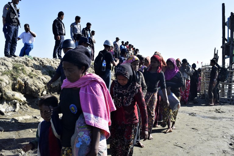 (FILES) In this file photo taken on November 30, 2018 Myanmar Navy personnel escort Rohingya Muslims back to their camp in Sittwe, Rakhine state, on November 30, 2018. (Photo by – / AFP)