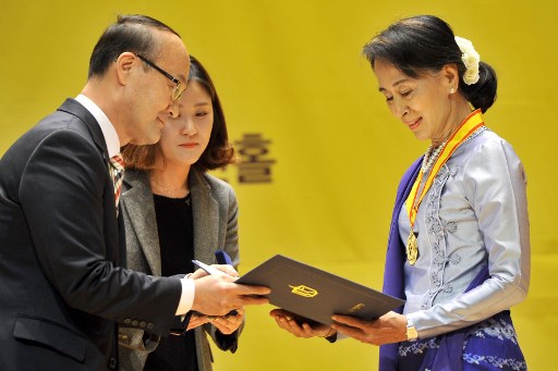 (FILES) This file photo taken on January 31, 2013 shows Myanmar’s Aung San Suu Kyi (R) receiving the Gwangju Prize for Human Rights in the southwestern city of Gwangju. – One of South Korean largest human rights groups will strip Myanmar’s de facto leader Aung San Suu Kyi of its 2004 prize because of her “indifference” to the atrocities against the Rohingya minority, organisers said on December 18, 2018. (Photo by Jung Yeon-je / AFP)