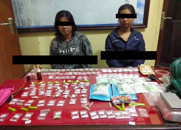 Dealers Ni Putu Sugiastini (39) and Novianti (31) with their confiscated drugs stash. Photo via Denpasar Viral.