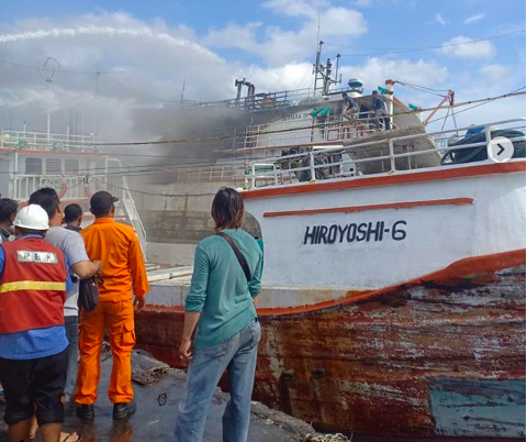 Crew and harbor staff look on as firefighters  extinguish Benoa harbor blaze. Photo via @info_lalulintasbali