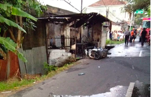 The victim’s motorbike lying outside the burnt-out stall. Photo via Facebook/Edie Ghana 
