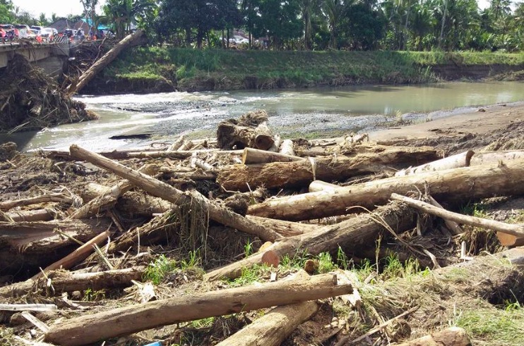 Mud, branches and debris blocked the bridge over Bilukpoh River, causing 11-hour delays. Photo: Facebook/Komang Budaarsa