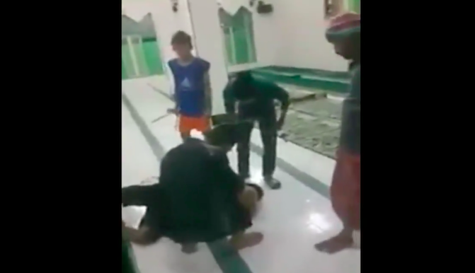 Locals in Gowa regency beating a man who was falsely accused of theft in a mosque. Photo: Video screengrab from Twitter