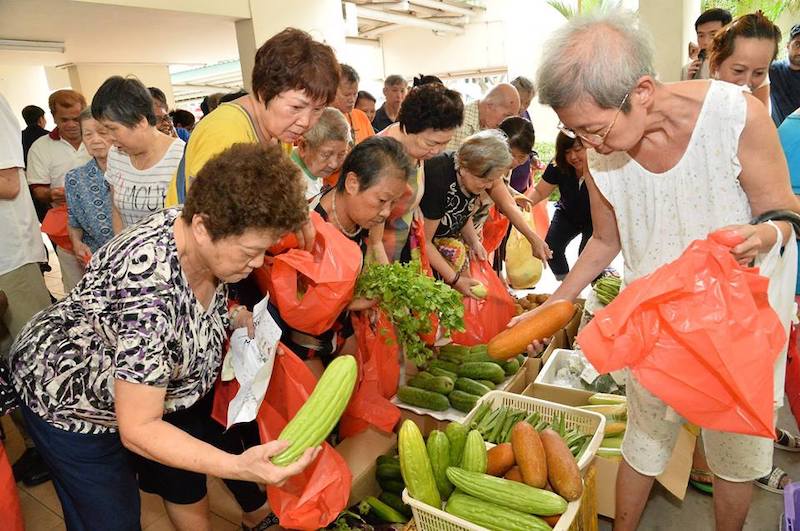 Residents of Dorset Road are busy snapping up the 300kg of fresh fruits and vegetables that were given out to needy residents (Photo: Melvin Yong / Facebook)