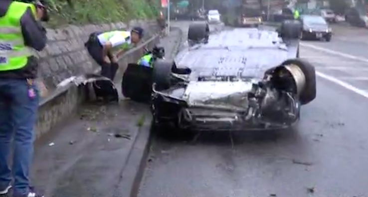 A black Ferrari overturned on Tai Po Road. it was one of six sports cars that police say were racing at 98 kilometers per hour, around twice the legal limit for that road. Screengrab via Apple Daily video.