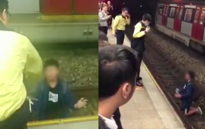 Station staff at Kowloon Tong station try and get a teenage boy off the train tracks after he ran on. Screengrab via Apple Daily video.
