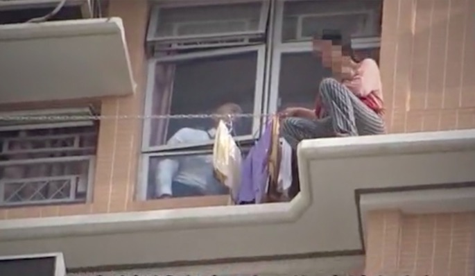 A 27-year-old new mom sitting on the ledge with a 2-month-old baby. Screengrab via Apple Daily video.