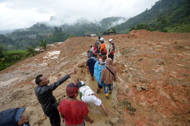 Rescue workers search for survivors at the site of a landslide triggered by heavy rain in Sukabumi, West Java province on January 1, 2019. – Rescuers are searching for survivors after a landslide triggered by heavy rain left at least nine people dead and dozens missing in western Indonesia, an official said on January 1, 2019. (Photo by – / AFP)
