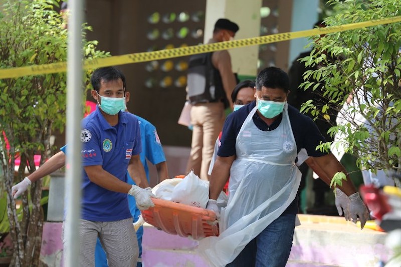In a file photo from January 2019, paramedics take away a body after four Thai civil defense volunteers, who were Muslims, were shot and killed outside of a school in the southern province of Pattani. Photo: Tuwaedaniya Meringing / AFP