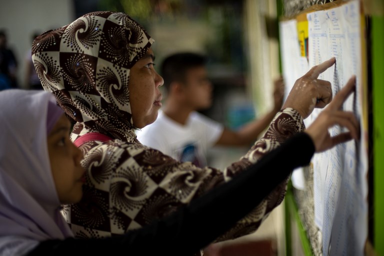Muslim women look for their names at a voting precinct in Maguindanao, on the southern island of Mindanao on January 21, 2019. (Photo: Noel Celis, AFP)