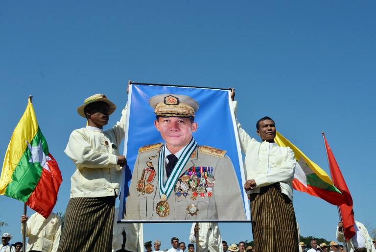 Myanmar men display a portrait of Myanmar military commander-in-chief Senior General Min Aung Hlaing during a rally in support of Myanmar military in capital Naypyiday on January 23, 2019. (Photo by Thet AUNG / AFP)