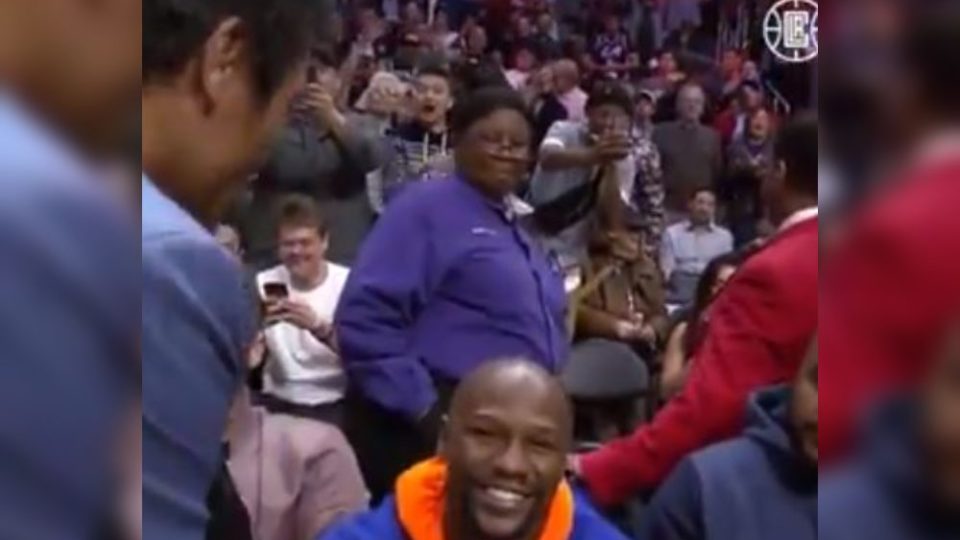 Floyd Mayweather is all smiles after he is greeted by Manny Pacquiao (left, in suit). Photo: Screenshot from video posted by LA Clippers 