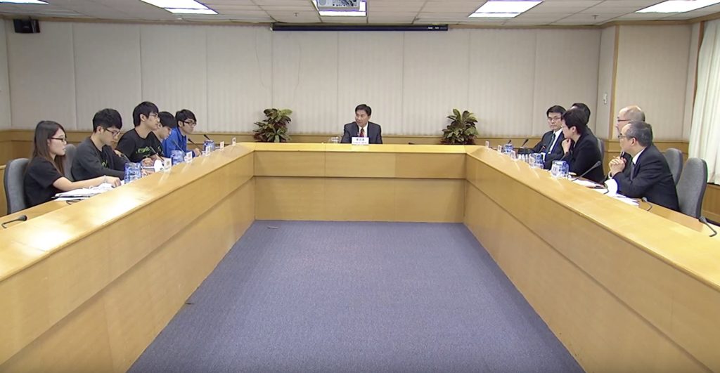 Umbrella Movement student leaders Yvonne Leung, Nathan Law, Alex Chow, Lester Shum, and Eason Chung debate with government officials Edward Yau, Rimsky Yuen, Carrie Lam, Raymond Tam and Lau Kong-wah. Screengrab via YouTube.