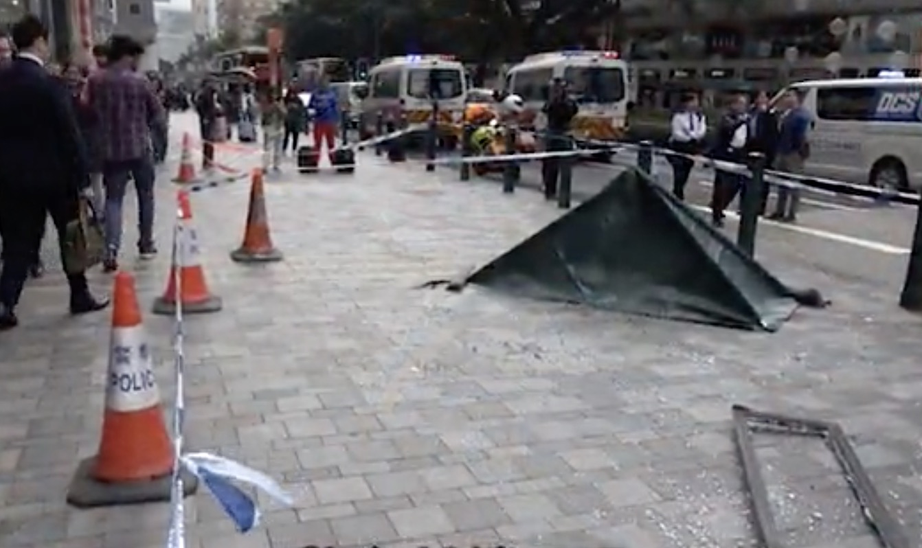Police have cordoned off the area where a window pane fell and landed on a female passer-by in Tsim Sha Tsui. Screengrab via Apple Daily video.
